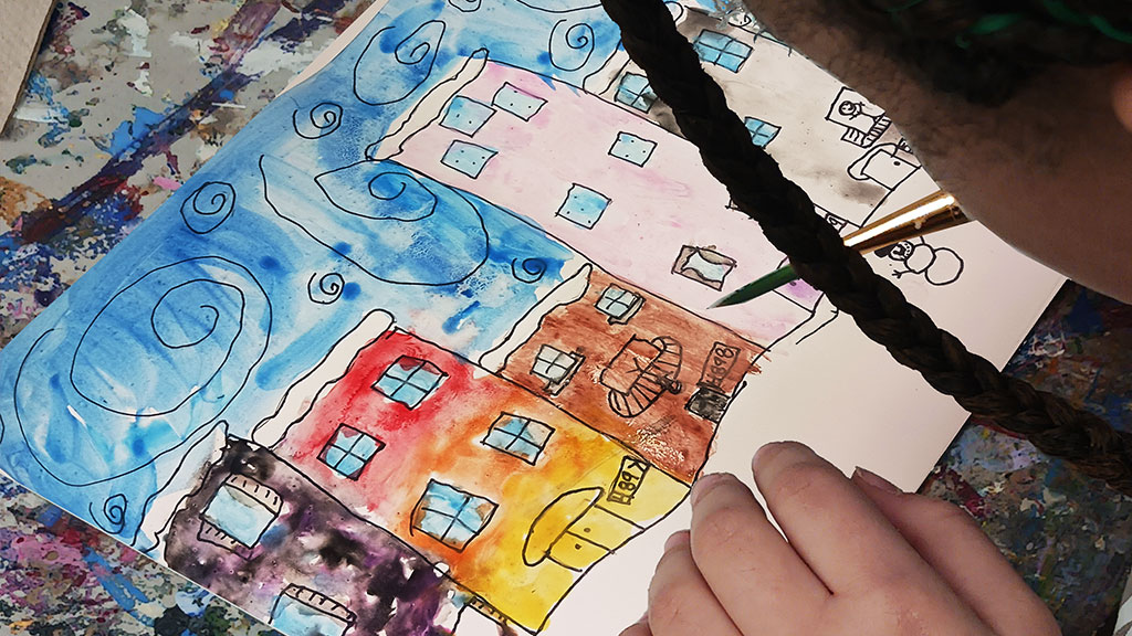 A brightly lit ceramics studio with a diverse group of artists working independently and having fun