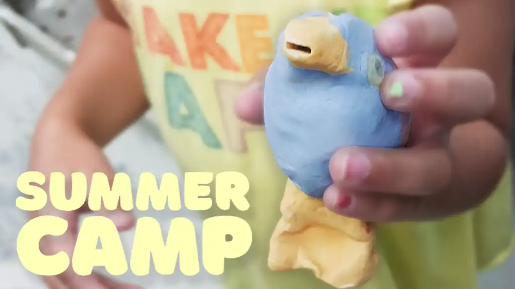 A young artist presenting a ceramic blue-bird. Promoting Summer Camp